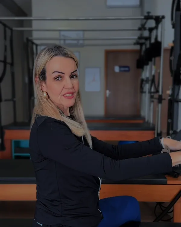 Virgínia Carrara no Reformer, com os aparelhos do studio ao fundo